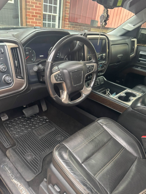 Detailed GMC Denali driver's area with clean leather, dashboard and floor mats